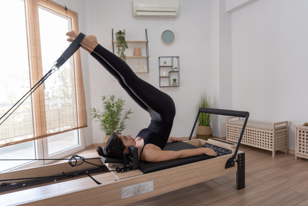 woman doing pilates on reformer 